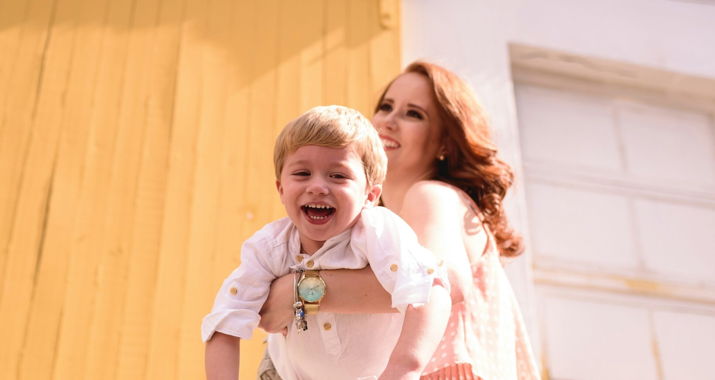 Mom holding son, smiling blonde boy, mom with red hair.